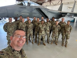 Airmen post in front of a jet