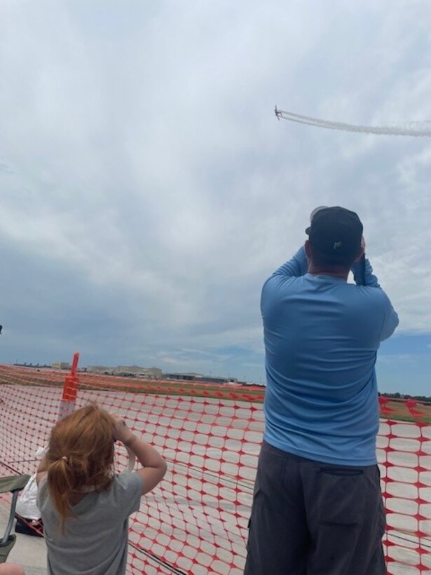 A man and child photograph a plane