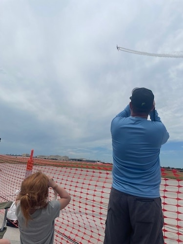 A man and child photograph a plane