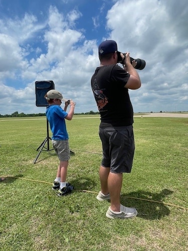 A man and child take photos.