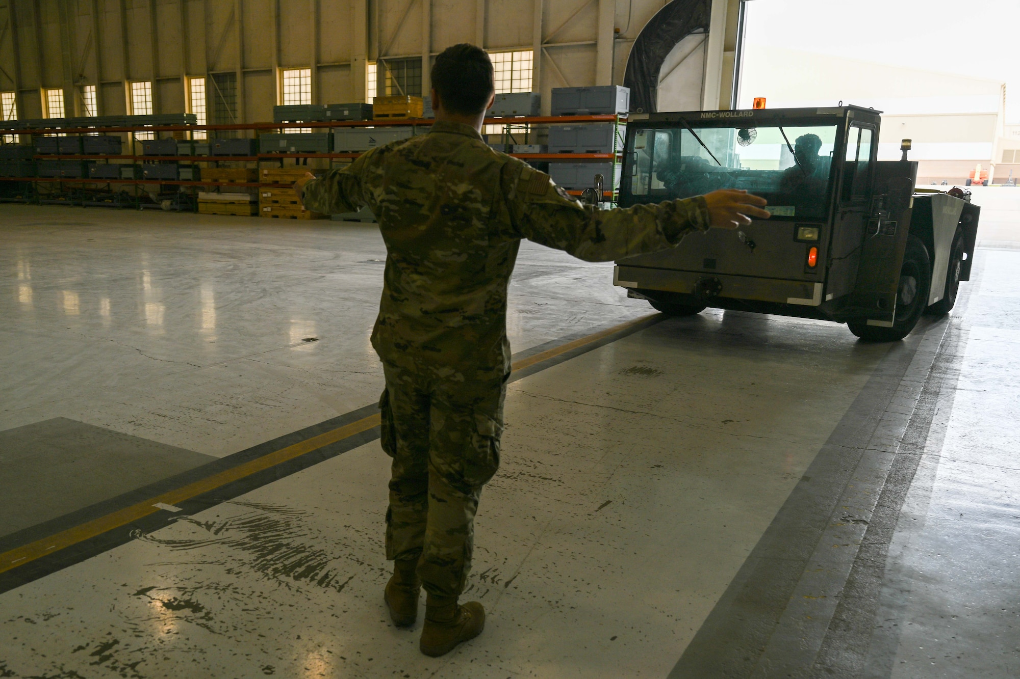 Senior Airman Devon Moody, 22nd Maintenance Squadron aerospace maintenance journeyman, marshals a pallet jack truck at McConnell Air Force Base, Kansas, April 15, 2024. Due to the possibility of high winds and hail, the majority of McConnell’s aircraft left the base for a weather relocation. (U.S. Air Force photo by Airman 1st class William Lunn)