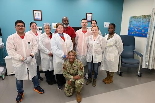 The laboratory team stands next to each other to take a group photo.
