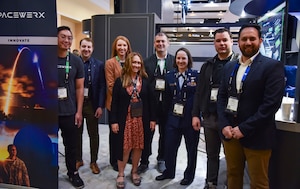 The SpaceWERX team poses for a picture at their Space Symposium booth at the Broadmoor in Colorado Springs, Colorado, April 10, 2024.