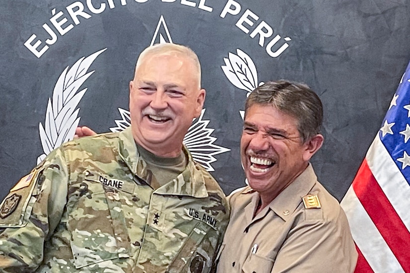 A U.S. Army general laughs with a foreign service member.