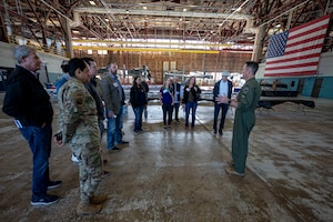 people stand together listening to a person talk