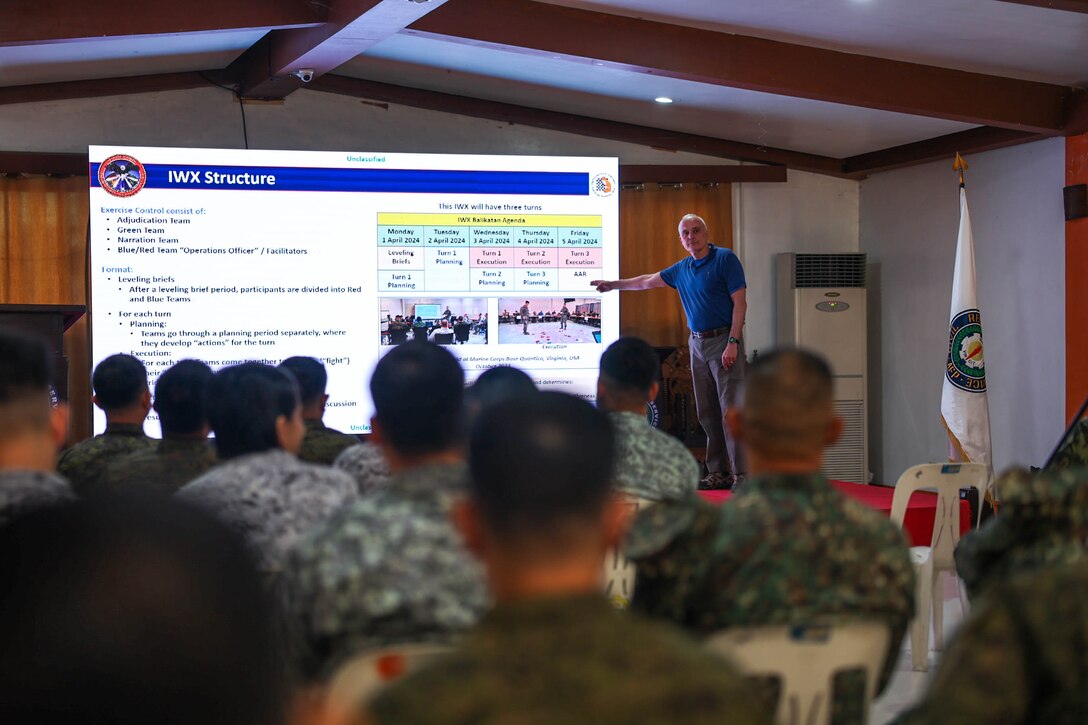James McNeive, Deputy Operations Officer, U.S. Marine Corps Information Operations Center, conducts an overview brief to participants of the Information Warfighter Exercise, held before the conduct of Exercise Balikatan 24, at Camp Aguinaldo, Philippines, April 1, 2024. IWX is a week-long matrix-style wargame that advances the combined information-related capabilities of the U.S. and Armed Forces of the Philippines. BK 24 is an annual exercise between the Armed Forces of the Philippines and the U.S. military designed to strengthen bilateral interoperability, capabilities, trust, and cooperation built over decades of shared experiences. (U.S. Marine Corps photo by Cpl. Brian Knowles)