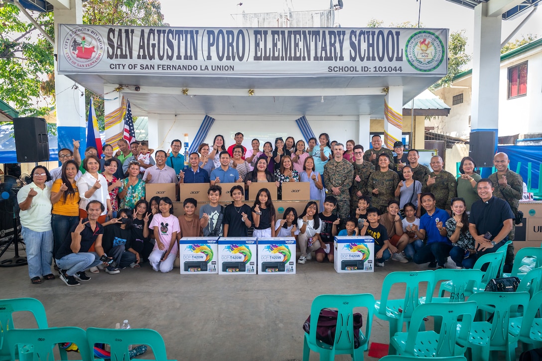 Philippine and U.S. service members pose for a photograph with barangay captains, religious leaders, San Fernando officials, La Union residents, San Agustin Elementary School faculty and staff, and students during a ‘Bundles of Joy’ event held before Exercise Balikatan 24 at San Agustin Elementary School in San Fernando, La Union, Philippines, April 13, 2024. The ‘Bundle of Joy’ delivery consisted of televisions, laptops, printers, and school supplies to improve the learning environment for students, staff, and San Agustin Elementary School faculty. BK 24 is an annual exercise between the Armed Forces of the Philippines and the U.S. military designed to strengthen bilateral interoperability, capabilities, trust, and cooperation built over decades of shared experiences. (U.S. Marine Corps photo by Cpl. Trent A. Henry)