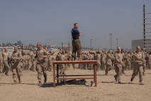 U.S. Marine Corps Staff Sgt. Jacob Wade, a chief drill instructor with Lima Company, 3rd Recruit Training Battalion, leads recruits in warm-ups prior to the confidence course at Marine Corps Recruit Depot San Diego, California, April 11, 2024. The confidence course allows recruits to become physically and mentally stronger by overcoming obstacles that require strength, balance, and determination. (U.S. Marine Corps photo by Lance Cpl. Alexandra M. Earl)