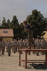 A U.S. Marine Corps drill instructor with Lima Company, 3rd Recruit Training Battalion, provides instruction to recruits prior to the confidence course at Marine Corps Recruit Depot San Diego, California, April 11, 2024. The confidence course allows recruits to become physically and mentally stronger by overcoming obstacles that require strength, balance, and determination. (U.S. Marine Corps photo by Lance Cpl. Alexandra M. Earl)