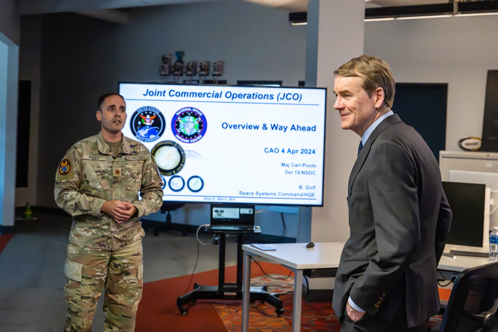 U.S. Space Force Maj. Carl Poole, Joint Commercial Operations cell site lead, left, briefs senior U.S. Sen. Michael Bennet of Colorado during Bennet’s immersion of the JCO at Colorado Springs, Colo., April 4, 2024. The JCO is an extension of the National Space Defense Center operations floor, and it leverages commercial providers to provide diverse, timely Space Domain Awareness in direct support of the NSDC’s core protect and defend mission. The NSDC is one of five operations centers for U.S. Space Forces – Space. The S4S mission is to plan, integrate, conduct, and assess global space operations in order to deliver combat relevant space effects, in, from, and to space, for Combatant Commanders, Coalition partners, the Joint Force, and the Nation. (U.S. Space Force photo by Dalton Prejeant)