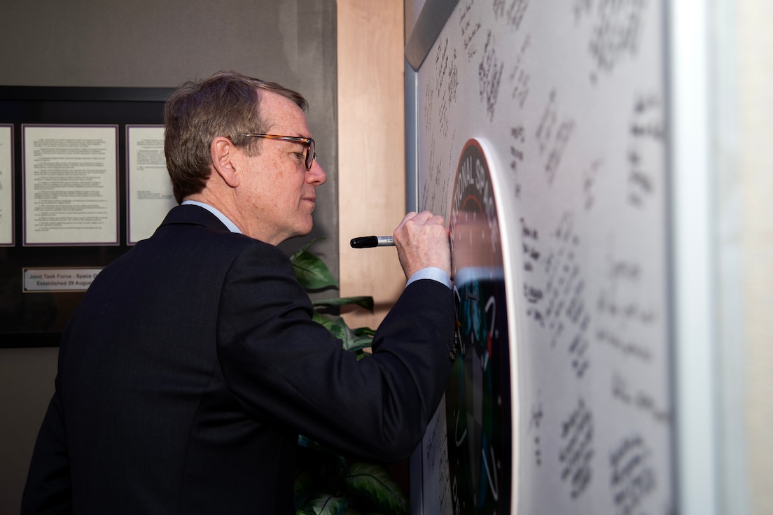 Senior U.S. Sen. Michael Bennet of Colorado, writes a message on the National Space Defense Center’s board during an immersion of the NSDC at Colorado Springs, Colo., April 4, 2024. The NSDC directly supports space defense unity of effort and expands information sharing in space defense operations among the DoD, National Reconnaissance Office, and other interagency partners. The NSDC is one of five operations centers for U.S. Space Forces – Space. The S4S mission is to plan, integrate, conduct, and assess global space operations in order to deliver combat relevant space effects, in, from, and to space, for Combatant Commanders, Coalition partners, the Joint Force, and the Nation.  (U.S. Space Force photo by Dennis Rogers)