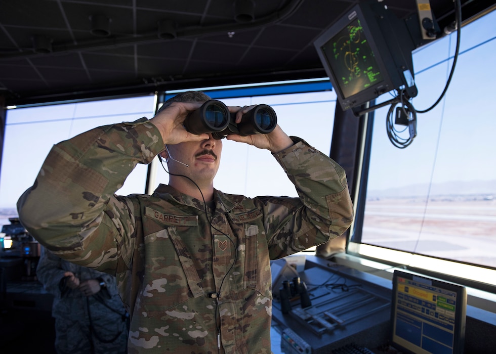 Staff Sgt. George Garrett, 56th Operation Support Squadron air traffic controller, scans the horizon for a pair of F-35 Lightning II aircraft returning from a mission from the Air Traffic Control Tower July 15, 2019, at Luke Air Force Base, Arizona