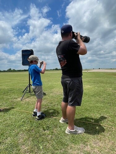 A man and child take photos.