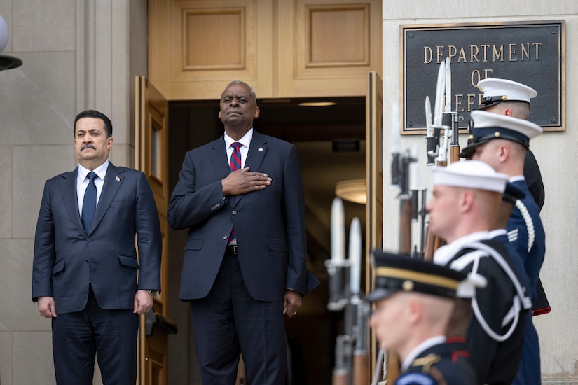 Two men stand on the steps of the Pentagon during a ceremony.