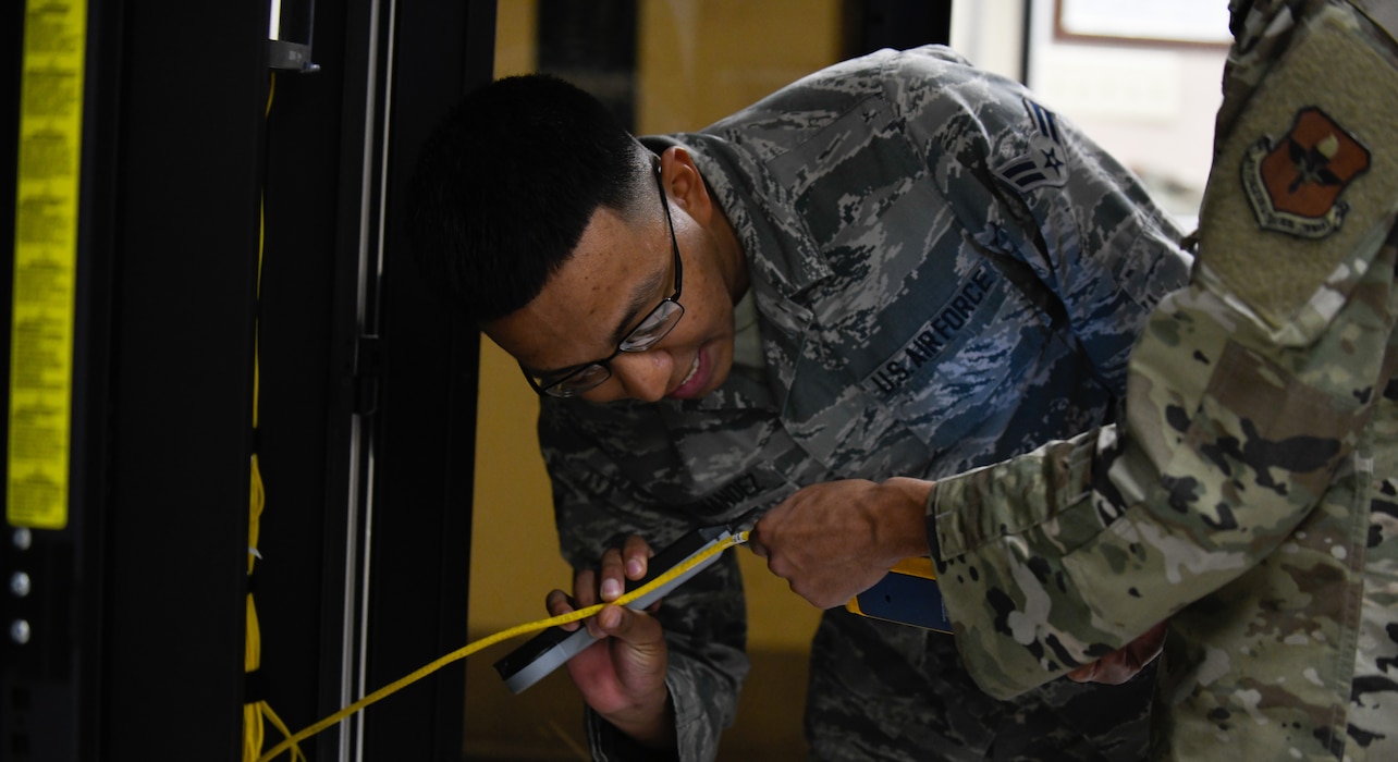 Airman 1st Class Martin Fernandez, 56th Communication Squadron client system technicians, inspects a cable line for a port installation controller in a server room at the 56th CS building Oct. 22, 2019 at Luke Air Force Base, Arizona.