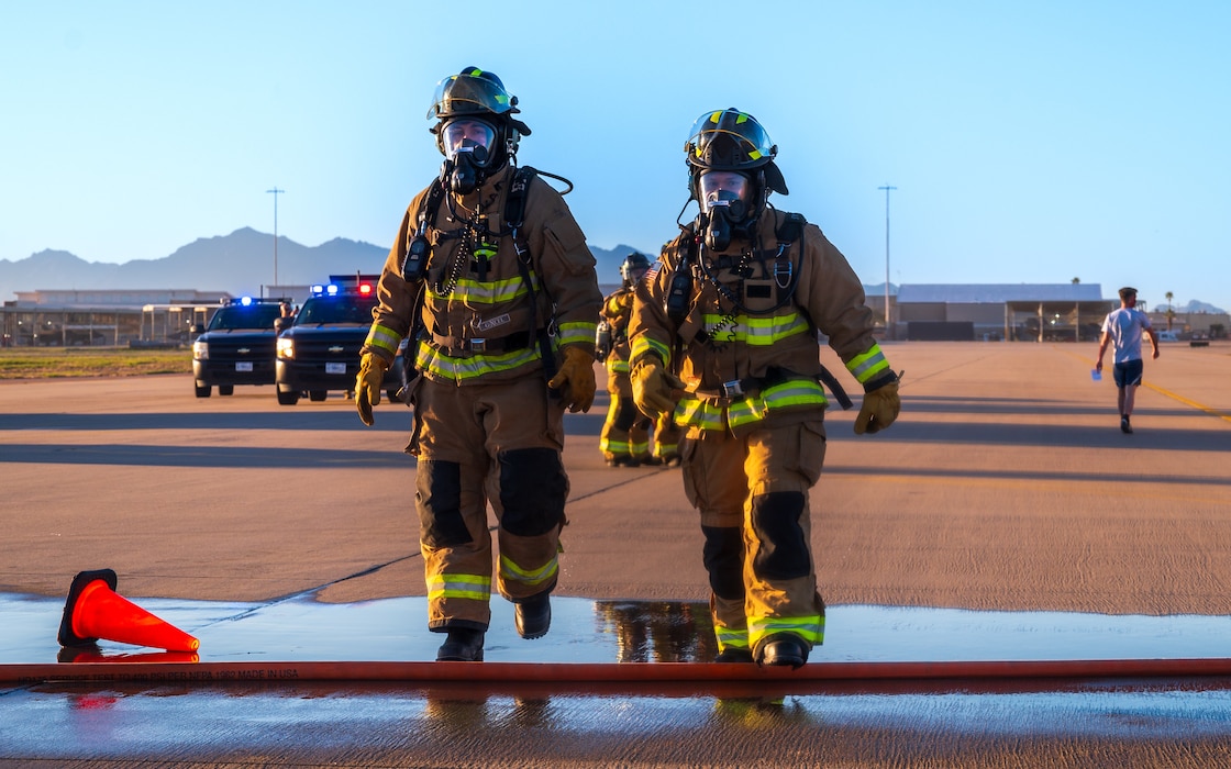 U.S. Air Force Airmen assigned to the 56th Civil Engineer Squadron walk on the flightline during a mass casualty exercise, Feb. 21, 2024, at Luke Air Force Base, Arizona.