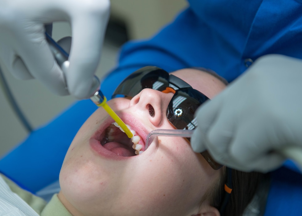 A dental technician performs a dental cleaning for Airman 1st Class Angel Baker, 63rd Aircraft Maintenance Squadron crew chief, during an annual visit Nov. 13, 2019 at the 56th Medical Group dental clinic on Luke Air Force Base, Arizona.