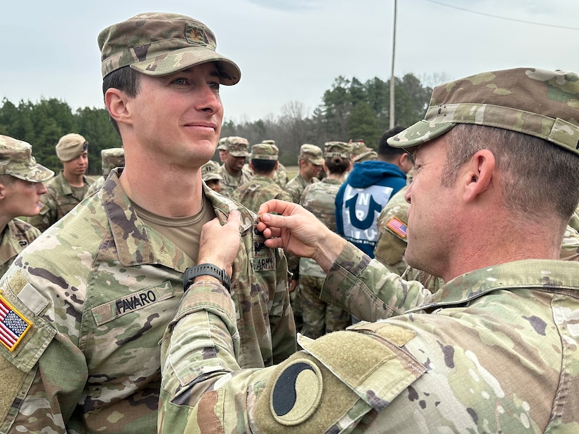 Maj. Josh Favaro, executive officer of the Virginia National Guard’s 229th Brigade Engineering Battalion, 116th Infantry Brigade Combat Team, receives the Expert Soldier Badge from Sgt. Maj. Justin Walkup, the 116th Infantry Brigade Combat Team operations sergeant major, March 15, 2024, at Fort Walker, Virginia.
