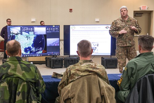 Lt. Col. Bartley War, Chief of Standardization and Evaluation, Joint Forces Headquarters Michigan (JFHQ-MI) Kelly Johnson Joint All Domain Innovation Center (KJJADIC,) delivers a presentation on innovation initiatives happening in Michigan to a delegation from Headquarters Air Force (HAF) and the Swedish Air Force. The Michigan National Guard (MING) hosted members of Headquarters Air Force) and Swedish Air Force at the National All Domain Warfighting Center (NADWC) on April 3-4, 2024. The visit gave those attending a look at training venues and opportunities offered at the NADWC in Michigan. (U.S. Air National Guard photo by Tech. Sgt. Drew Schumann)