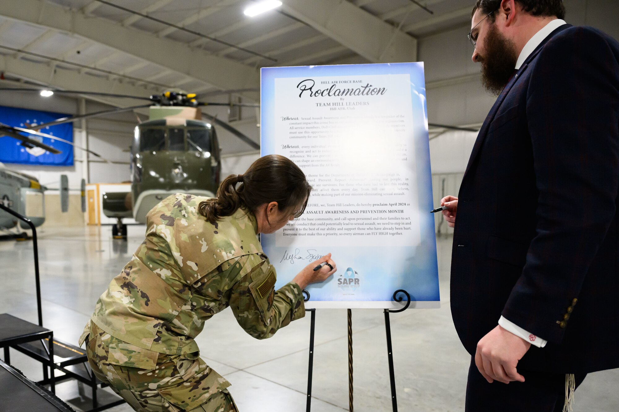 Col. Szwac signs the proclamation while Rabbi Zippel watches.