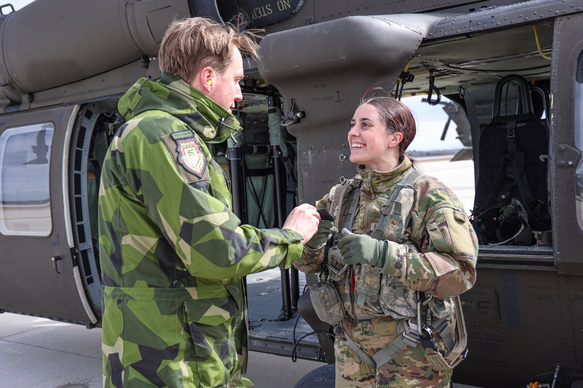 Lt Col Peter Sturesson, Swedish Air Force, exchanges unit patches with members of the Michigan National Guard, following an aerial tour of the National All Domain Warfighting Center (NADWC.) The Michigan National Guard (MING) hosted members of Headquarters Air Force (HAF) and Swedish Air Force at NADWC on April 3-4, 2024. The visit gave those attending a look at training venues and opportunities offered at the NADWC in Michigan. (U.S. Air National Guard photo by Tech. Sgt. Drew Schumann)