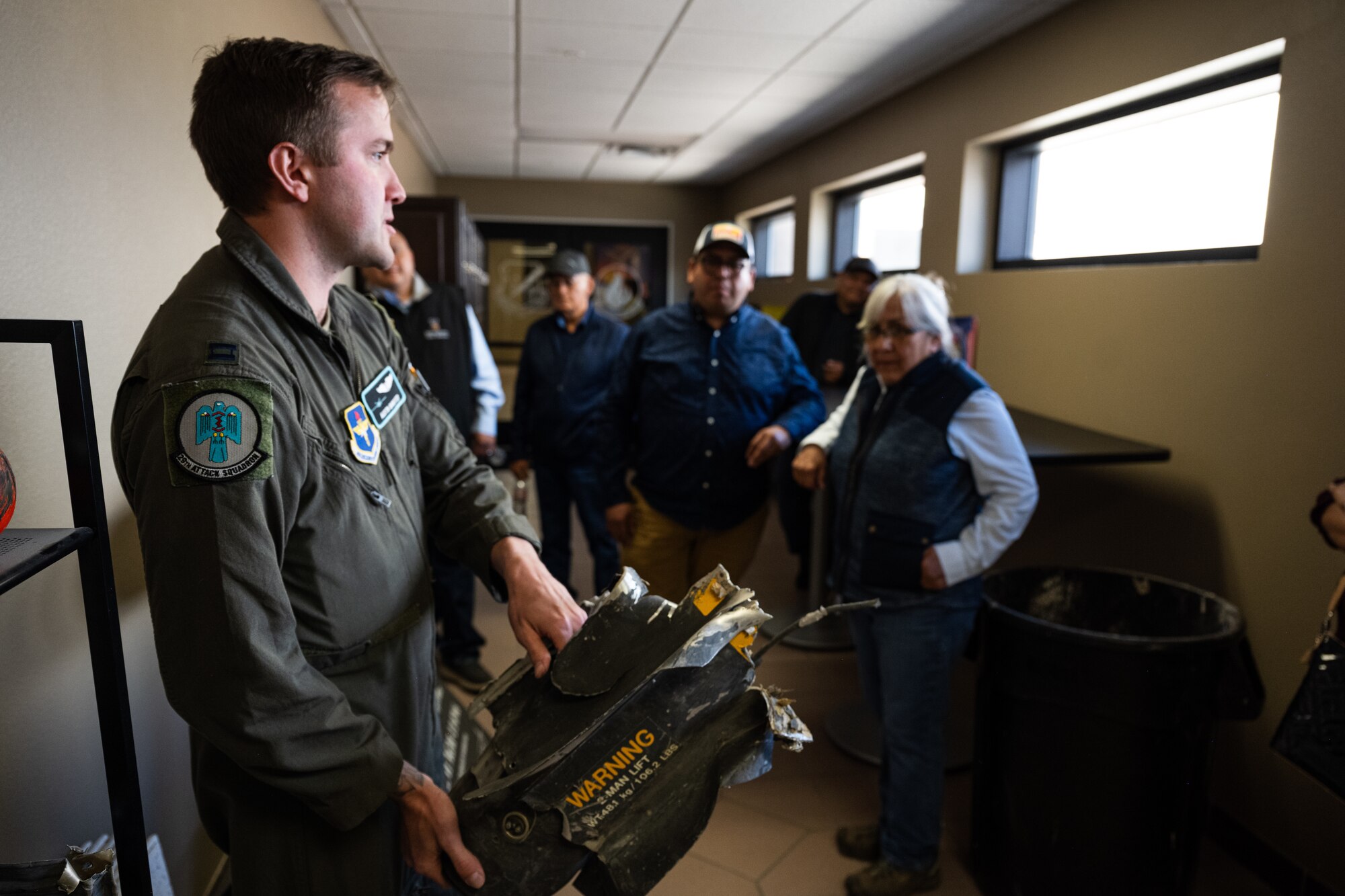 U.S. Air Force Capt. Austin Banister, 29th Attack Squadron flight commander, presents fragments of a deployed Hellfire missile to Mescalero Apache tribe members at Holloman Air Force Base, New Mexico, April 1, 2024.