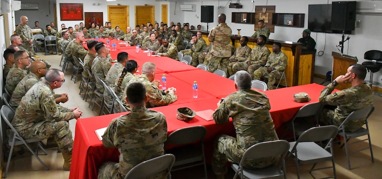Large group of U.S. Army Soldiers seated at connected tables.