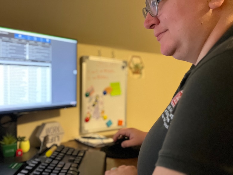 Female civilian works at computer at a home office.