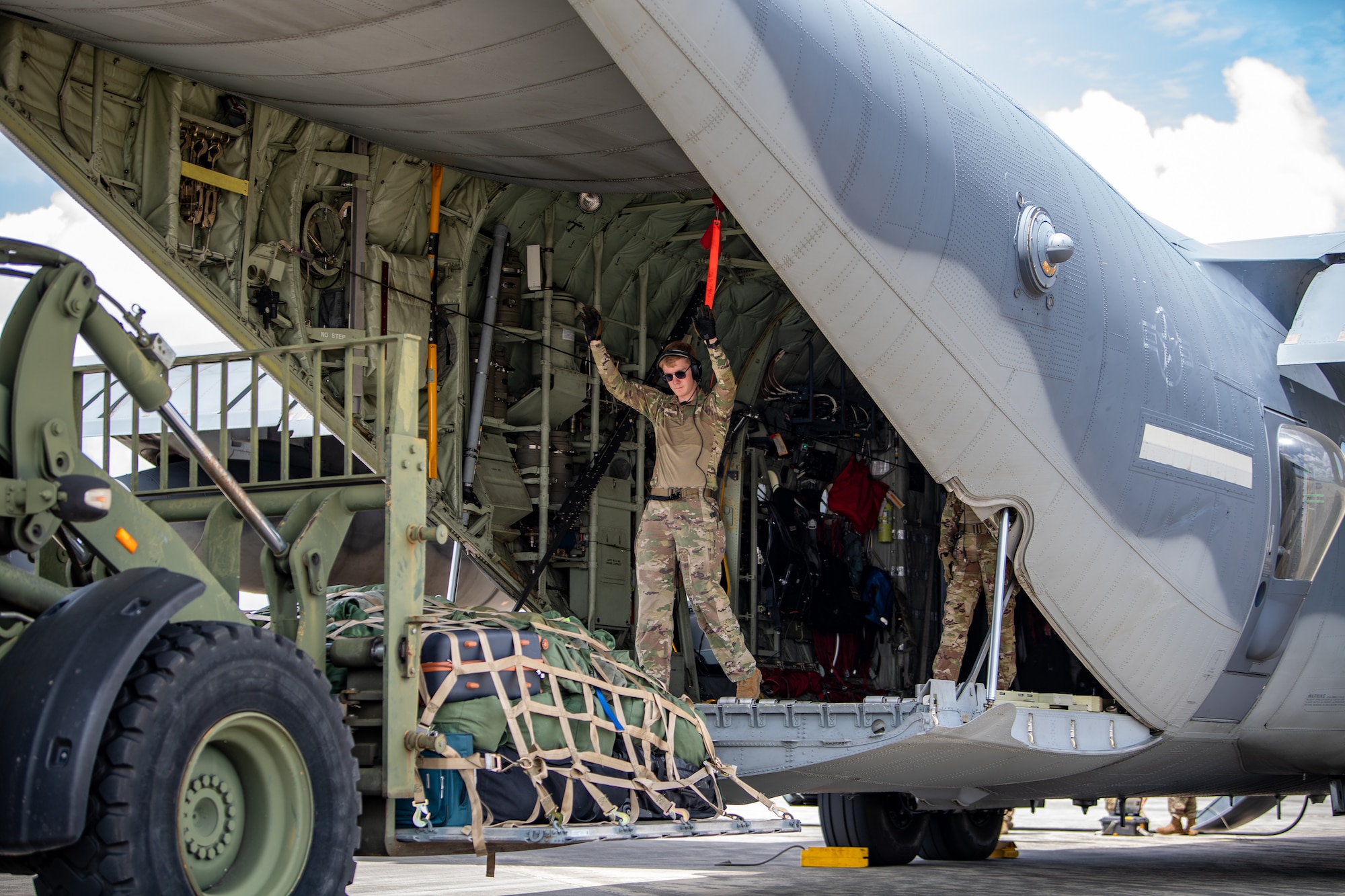 U.S. Air Force Airman 1st Class Blake Daggy, 71st Rescue Squadron loadmaster, directs a forklift to offload cargo during exercise Ready Tiger 24-1 at Savannah Air National Guard Base, Georgia, April 10, 2024. The 71st RQS provided essential airlift support for transporting cargo and personnel and responded to combat search and rescue scenarios throughout the exercise. During Ready Tiger 24-1, the 23rd Wing will be evaluated on the integration of Air Force Force Generation principles such as Agile Combat Employment, integrated combat turns, forward aerial refueling points, multi-capable Airmen, and combat search and rescue capabilities. (U.S. Air Force photo by Senior Airman Courtney Sebastianelli)