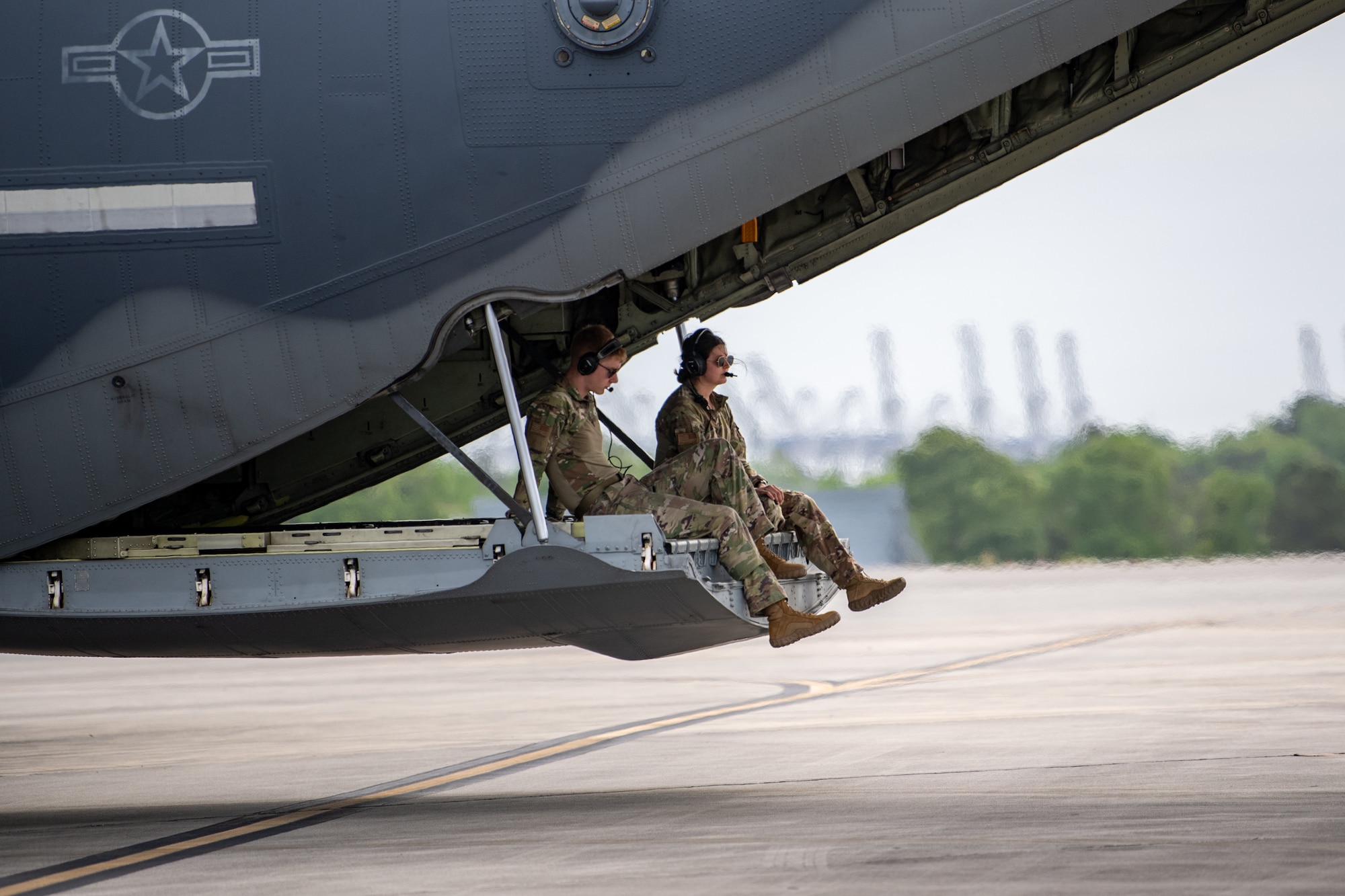 U.S. Air Force Airman 1st Class Blake Daggy and Senior Airman Sierra Orozco, 71st Rescue Squadron loadmasters, sit on the ramp of an HC-130J Combat King II during Exercise Ready Tiger 24-1 at Savannah Air National Guard Base, Georgia, April 10, 2024. Ready Tiger 24-1 is a readiness exercise demonstrating the 23rd Wing’s ability to plan, prepare and execute operations and maintenance to project air power in contested and dispersed locations, defending the United States’ interests and allies. (U.S. Air Force photo by Senior Airman Courtney Sebastianelli)