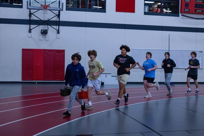U.S. Marine Corps Staff Sgt. Benjamin Dahlman, a production recruiter with Recruiting Sub-Station Kenosha, Recruiting Station Milwaukee, 9th Marine Corps Recruiting District, leads Wilmot Union high schoolers in gym class, at Wilmot Union High School, Wilmot, Wisconsin, April 9, 2024. During the gym classes students participated in Marine Corps style competitive workouts, learned about the importance of leadership, and given the chance to ask questions about Marine Corps benefits and opportunities. (U.S. Marine Corps photo by Cpl. Collette Hagen)