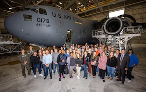 A large group photo in front of a C-17 Globemaster aircraft