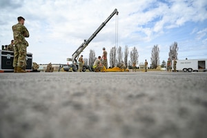 Airmen operate crane