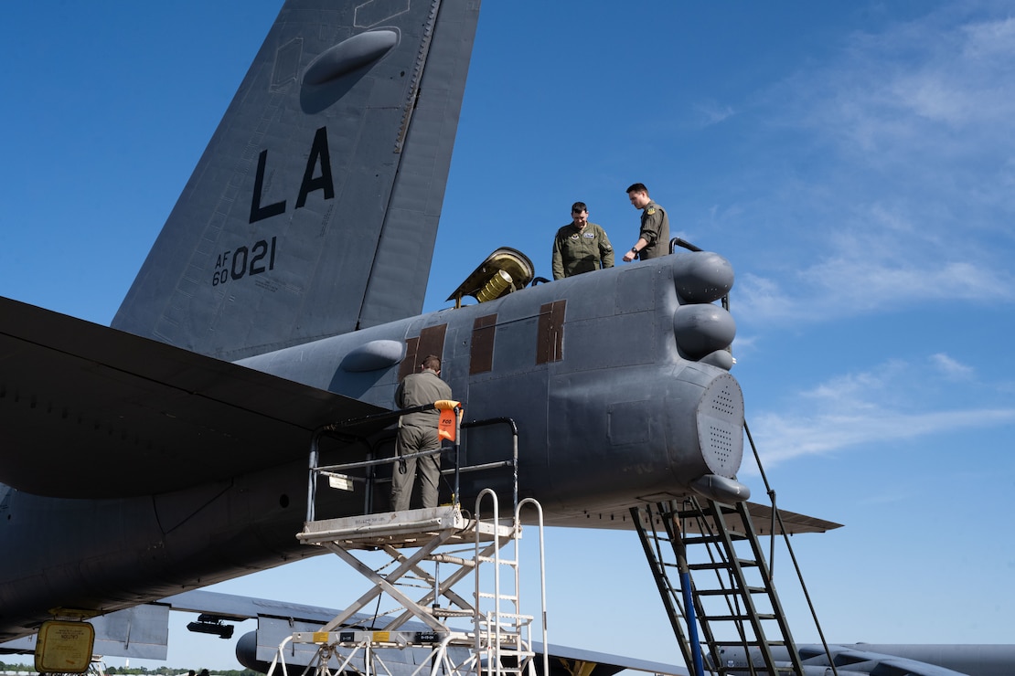 Senior Airman Justin Whitehead, 2nd Aircraft Maintenance Squadron crew chief, Capt. Joshua Benard, 20th Bomb Squadron radar navigator, and Capt. Stephen O’Donnell, 20th Bomb Squadron electron warfare navigator, prepare to load a drag chute into a B-52H Stratofortress after landing at Chennault International Airport, La., during exercise Bayou Vigilance April 12, 2024. This exercise was conducted with a focus on the safe and secure handling of assets and capabilities that comprise the nuclear triad. (U.S. Air Force photo by Senior Airman Nicole Ledbetter)