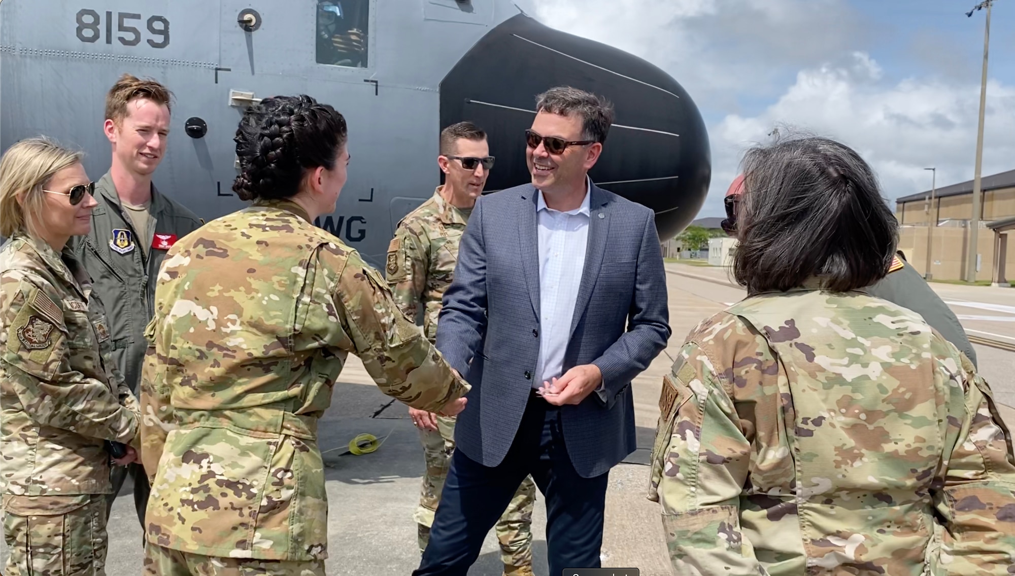 MS Secretary of State shakes the hand of female loadmaster near a C-130J Super Hercules.