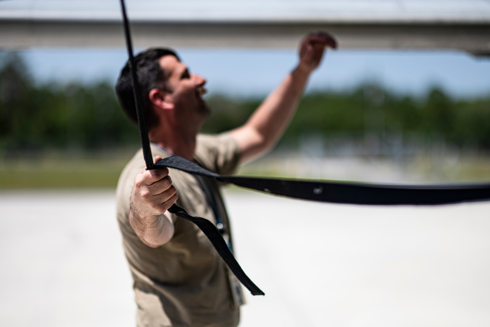 A U.S. Air Force Airman assigned to the 74th Fighter Generation Squadron holds a strap connected to an engine cover on an A-10C Thunderbolt II during Exercise Ready Tiger 24-1 at Avon Park Air Force Range, Florida, April 10, 2024. The 74th FGS provided required maintenance for the A-10s as they conducted training scenarios for the exercise. During Ready Tiger 24-1, exercise inspectors will assess the 23rd Wing's proficiency in employing decentralized command and control to fulfill air tasking orders across geographically dispersed areas amid communication challenges, integrating Agile Combat Employment principles such as integrated combat turns, forward aerial refueling points, multi-capable Airmen, and combat search and rescue capabilities. (U.S. Air Force photo by Tech. Sgt. Devin Boyer)