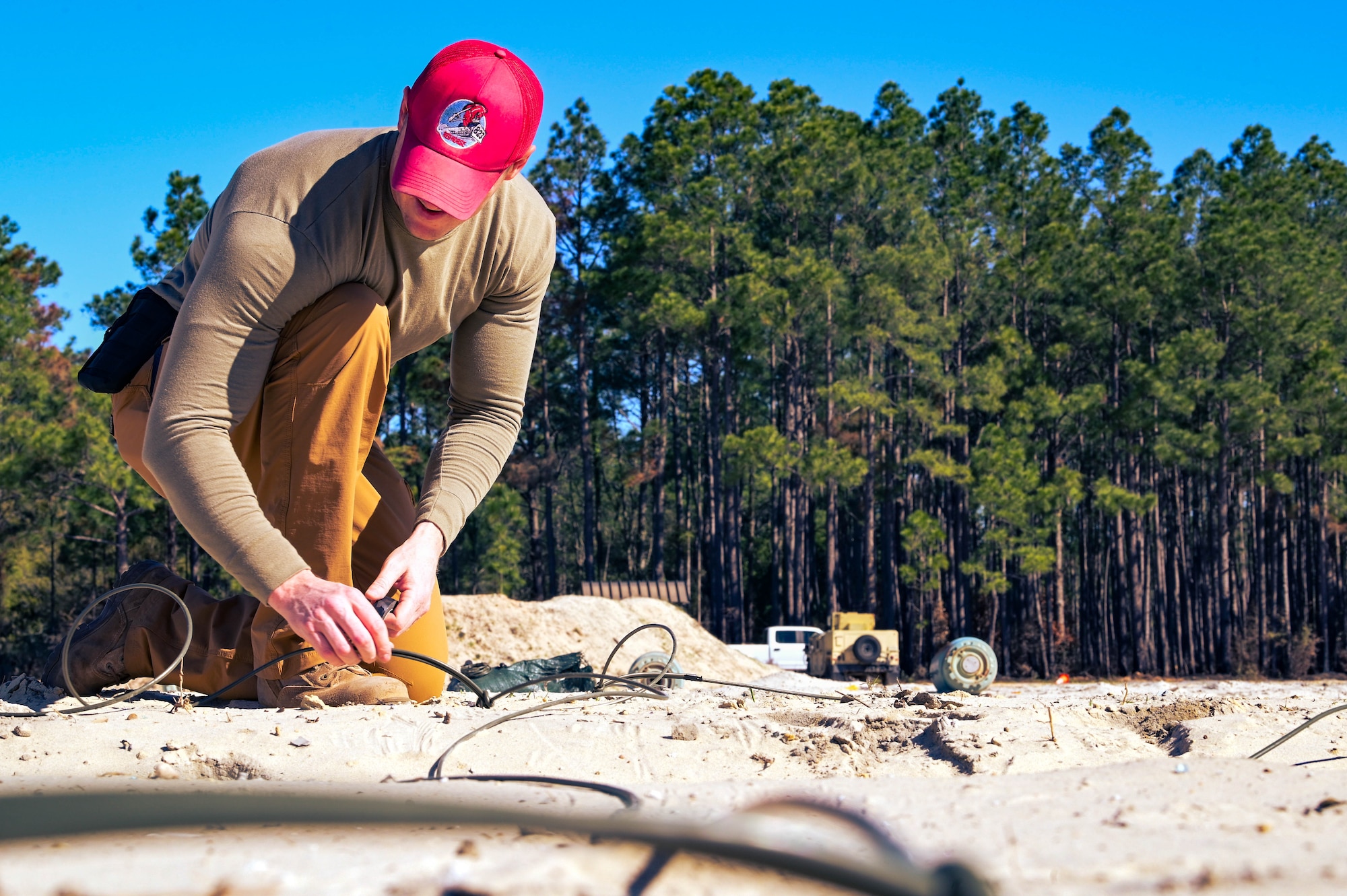 U.S. Air Force Tech Sgt. Derek Purdin, a 823rd Red Horse Squadron heavy equipment operator, ties a detonation cord to an explosive during demolition training at Hurlburt Field, Florida, March 28, 2024.