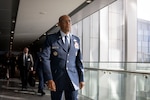 A man in uniform walks along a hallway.