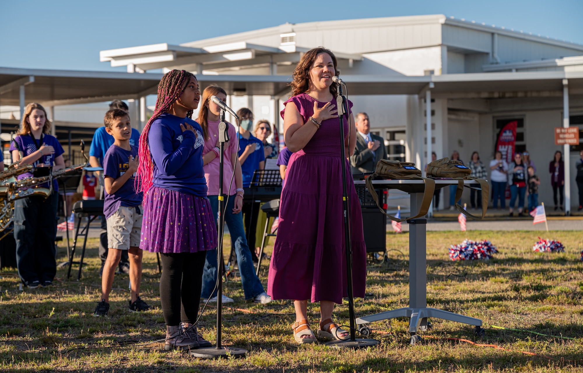 Two individuals say the national anthem