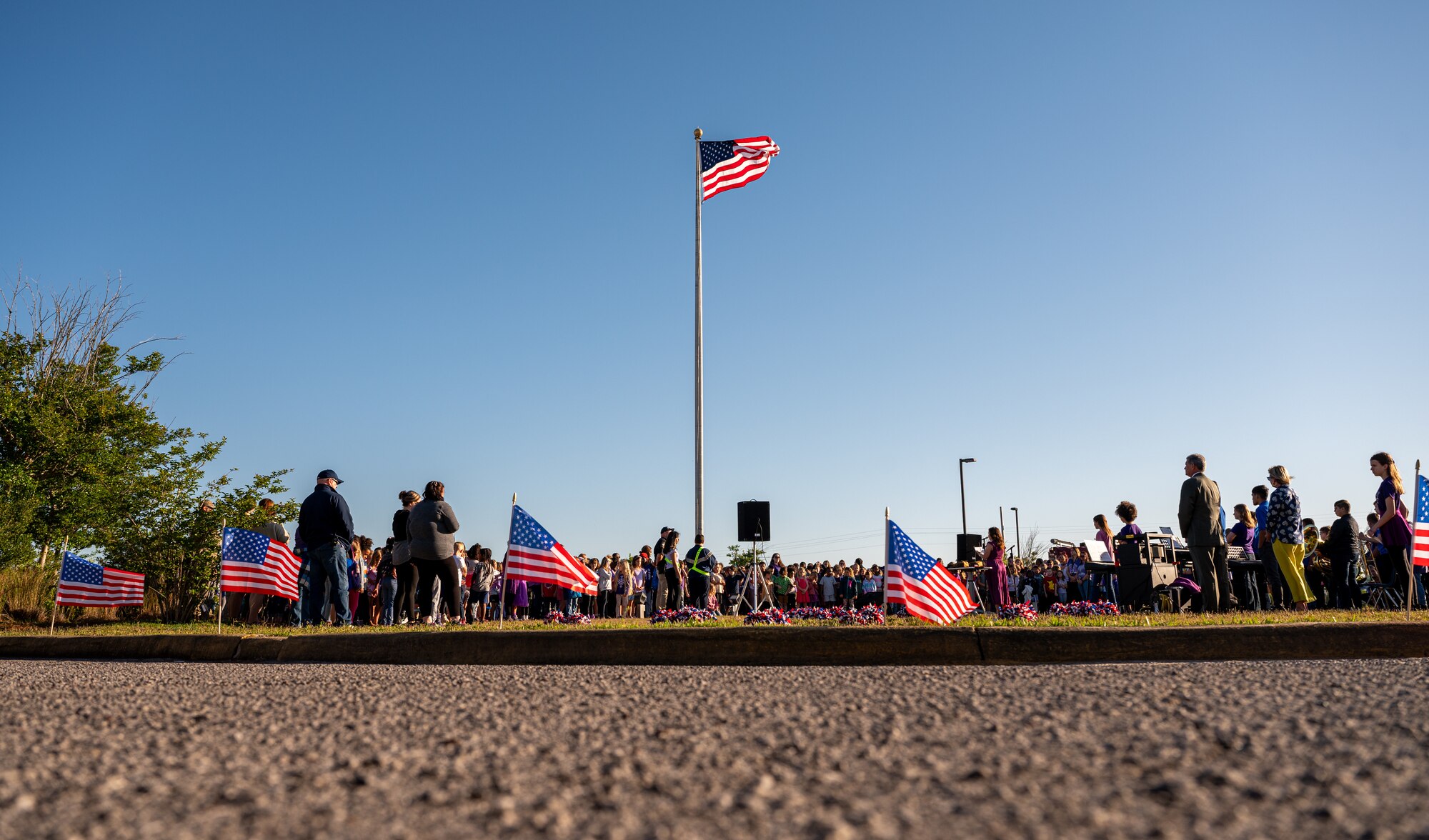 A crowd of people stand around a flag