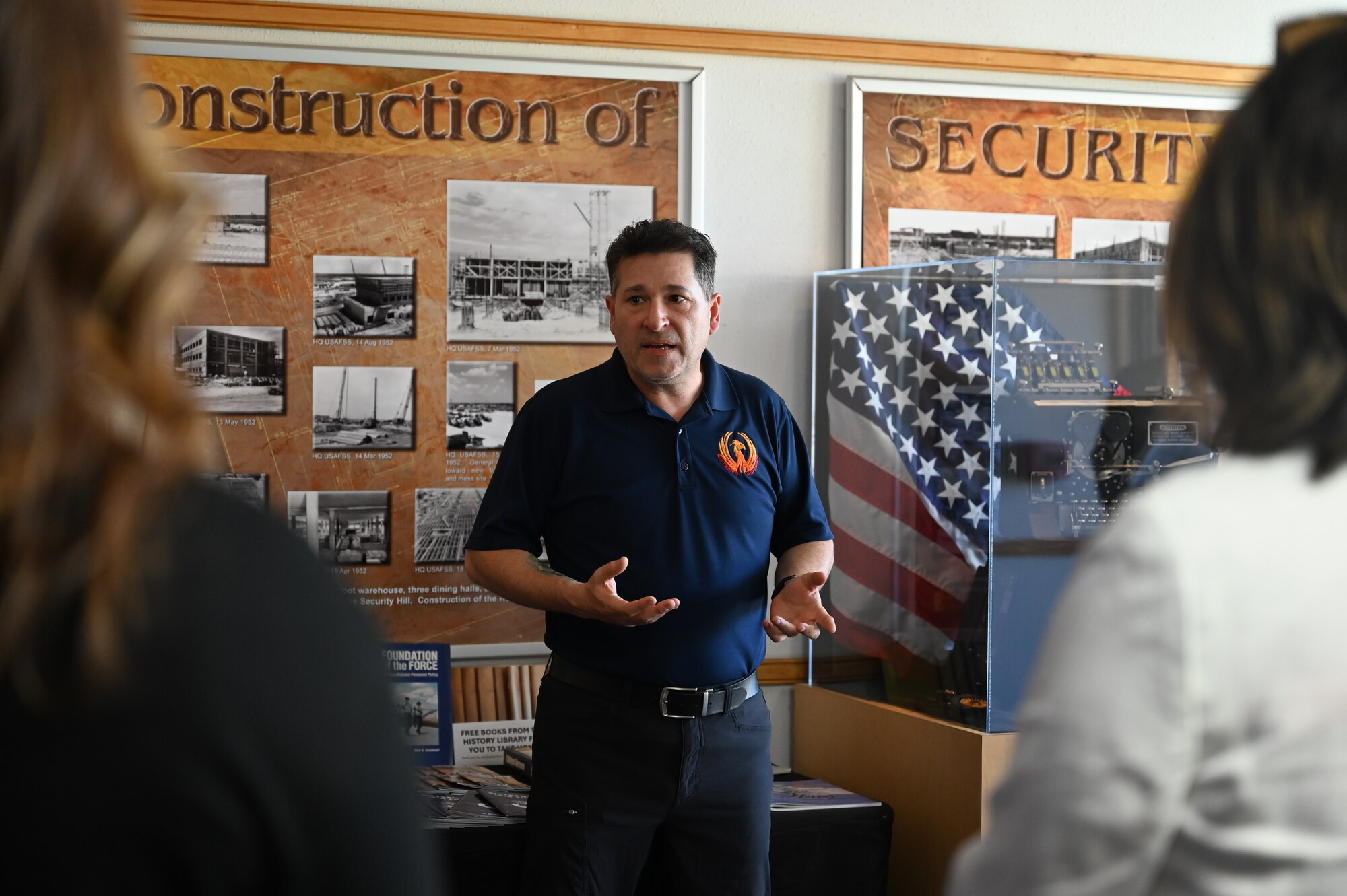 A Historian gives a tour of a history hallway with World War II displays.