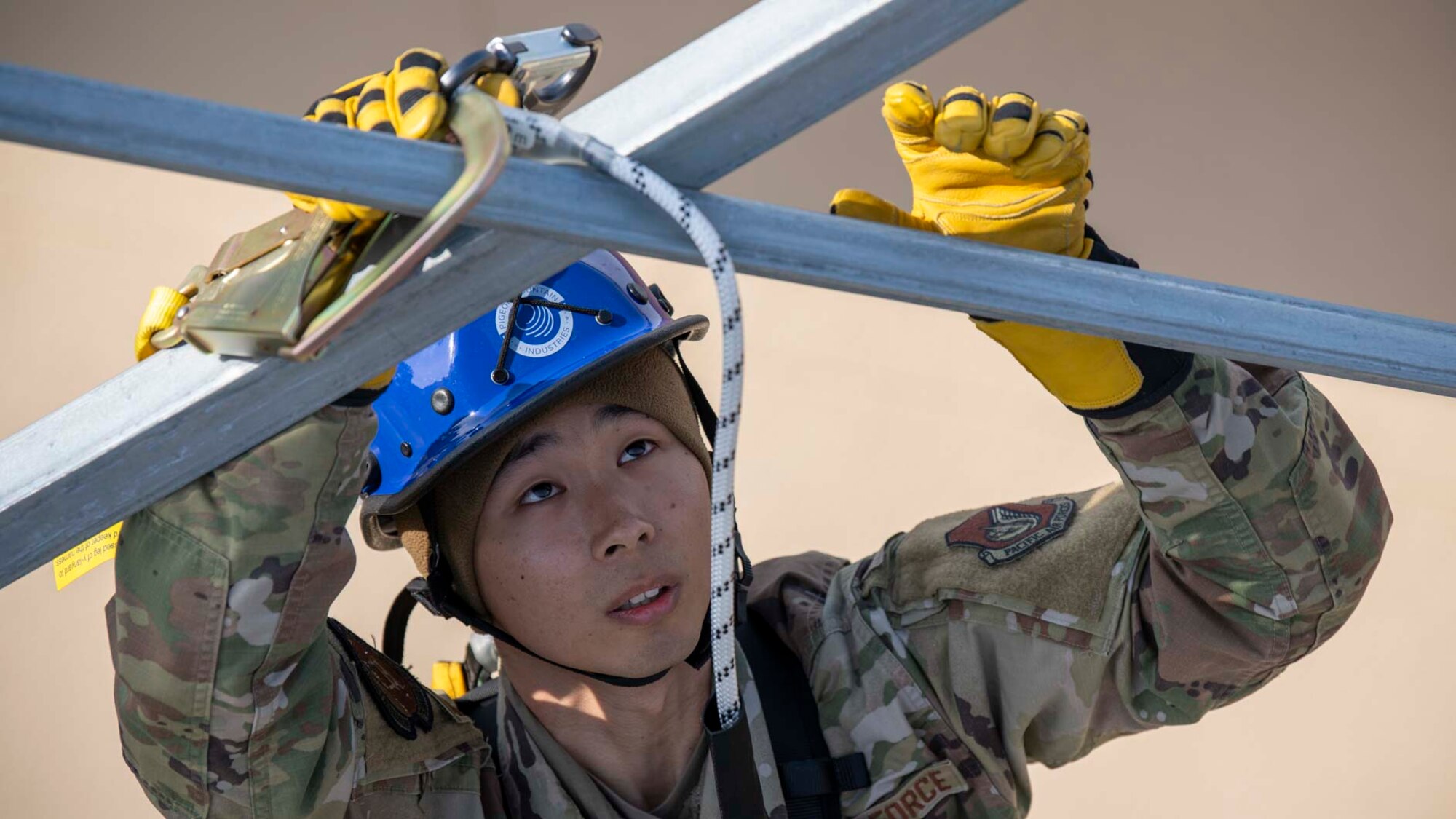 A military member climbs up a tower.