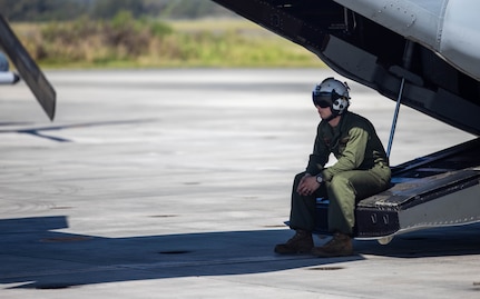 U.S. Marine Corps Cpl. Chase Coleman, an aircraft safety observer with Medium Tiltrotor Squadron (VMM) 268, Marine Aircraft Group 24, 1st Marine Aircraft Wing,  sits on the end of an MV-22B Osprey during preparation for Marine Rotational Force Darwin (MRF-D) at Marine Corps Air Station Kaneohe Bay, April 16, 2024. MRF-D is a deployment held in Australia that enhances capabilities and readiness of both of the United States Marine Corps and Australian Defense Force and continues to help strengthen the alliance between the two nations. VMM-268 will serve as the Aviation Combat Element for the upcoming iteration of MRF-D. (U.S. Marine Corps photo by Lance Cpl. Blake Gonter)