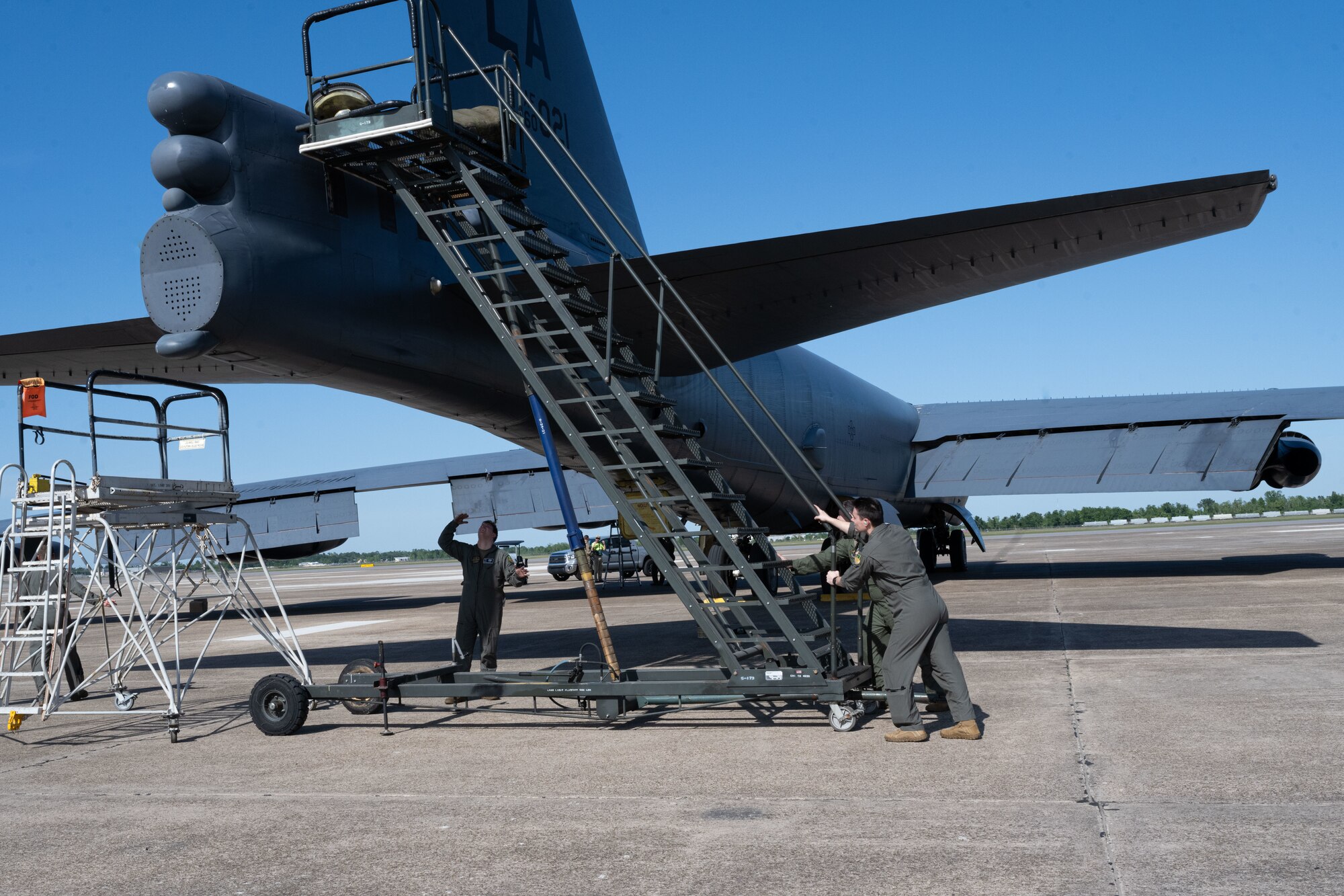 Senior Airman Justin Whitehead, 2nd Aircraft Maintenance Squadron crew chief, Capt. Joshua Benard, 20th Bomb Squadron radar navigator, and Capt. Stephen O’Donnell, 20th Bomb Squadron electron warfare navigator, line up stairs to a B-52H Stratofortress as they prepare to load a drag chute at Chennault International Airport, La., April 12, 2024. This was part of exercise Bayou Vigilance, which is held to enhance safety, security, and reliability of the bomber leg of the U.S. nuclear triad. (U.S. Air Force photo by Senior Airman Nicole Ledbetter)