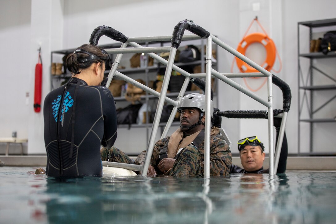 U.S. Marine Corps Staff Sgt. Xavier Jones, an aviation maintenance specialist with Marine Aviation Logistics Squadron 12 and a Georgia native, conducts preparatory drills during underwater egress training at Camp Humphreys, South Korea, April 4, 2024. Marines with Marine Aircraft Group 12 and Marine Wing Communication Squadron 18 traveled to South Korea for unit and joint-level training to increase combat readiness and proficiency on the Korean peninsula. (U.S. Marine Corps photo by Cpl. Samantha Rodriguez)