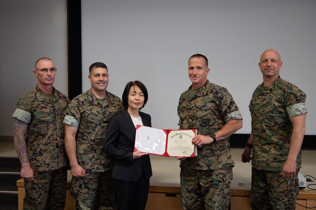 Yoko Seo, center left, a Japanese executive assistant with the Marine Corps Air Station Iwakuni protocol office, poses for a photo with the command of MCAS Iwakuni and Marine Corps Installations Pacific after receiving MCIPAC’s Master Labor Contractor of the Year award at MCAS Iwakuni, April 10, 2024. The Commanding General and Sergeant Major of MCIPAC visited MCAS Iwakuni to recognize outstanding work, and to speak and engage with Marines, Sailors, and civilians of the station about topics such as quality of life and leadership qualities. (U.S. Marine Corps photo by Lance Cpl. Colin Thibault)