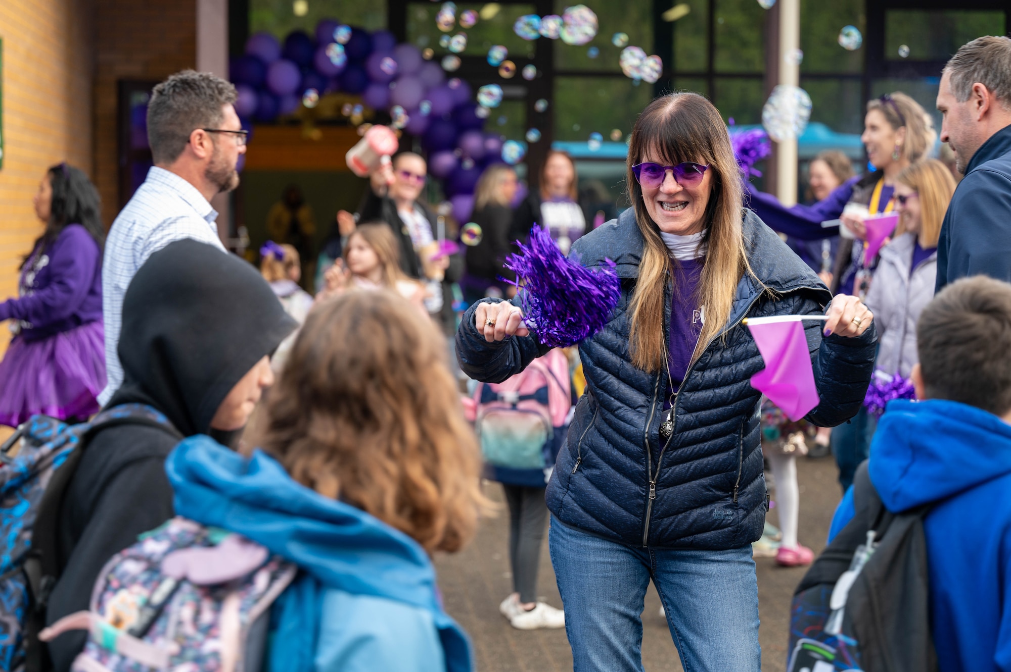A member of the Kaiserslautern Military Community greets children during Purple Up! Day at Ramstein Air Base, Germany, April 17, 2024.