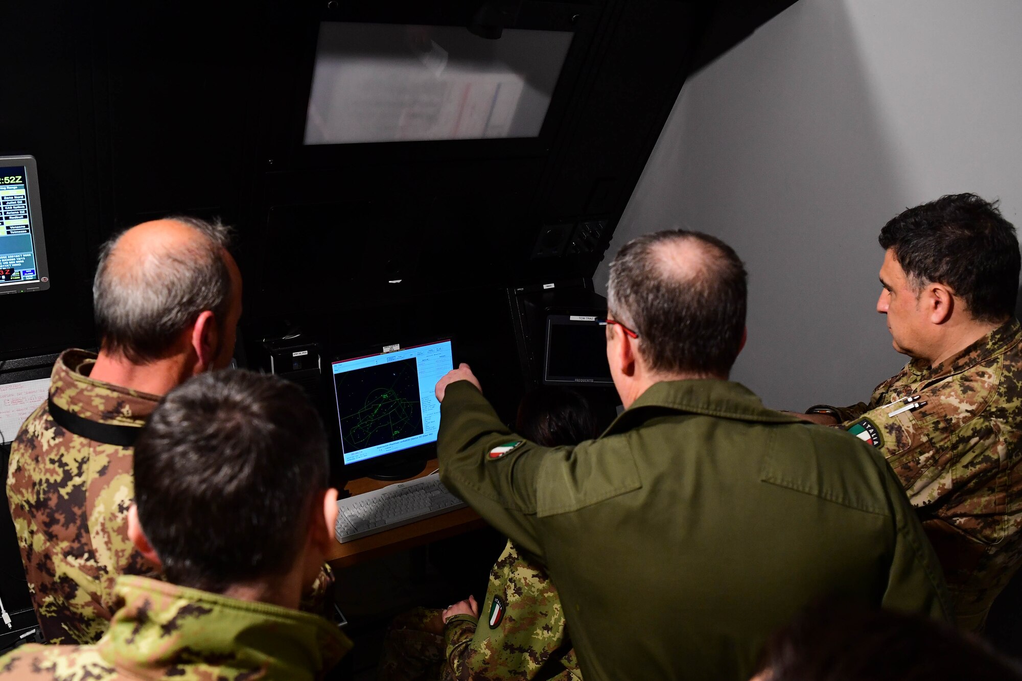 An Italian Air Force member points to a computer
