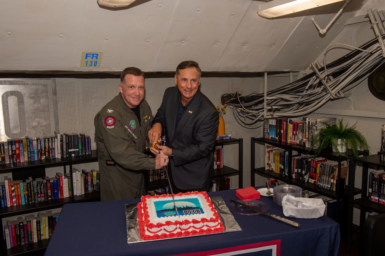 Capt. Daryle Cardone, commanding officer of the U.S. Navy’s only forward-deployed aircraft carrier, USS Ronald Reagan (CVN 76), and Scott Maskery, regional vice president for the United Service Operations (USO) Indo-Pacific regional office, cut a cake during the opening of a ship-based USO center aboard the ship while in-port Commander, Fleet Activities Yokosuka, April 17. Ronald Reagan, the flagship of Carrier Strike Group 5, provides a combat-ready force that protects and defends the United States, and supports alliances, partnerships and collective maritime interests in the Indo-Pacific region.