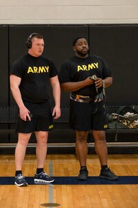 U.S. Army Staff Sgt. Travis Beeghley, left, and U.S. Army Spc. Darnell Boynton, right, watch fellow athletes compete in the powerlifting event at the 2024 Army Trials, Fort Liberty, North Carolina